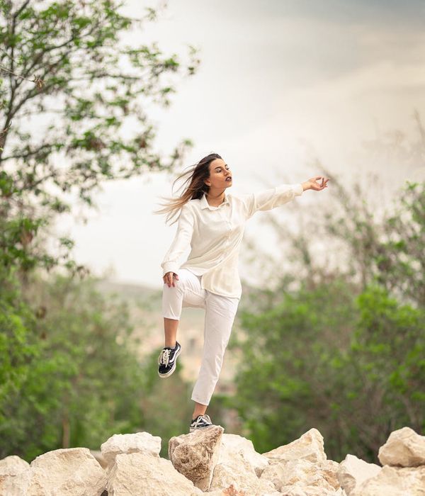Woman in a calming yoga pose in a softly lit, peaceful environment.